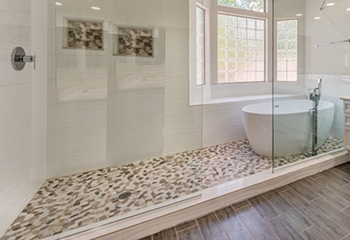 Elegant bathroom featuring a freestanding bathtub and pebble stone shower floor in Playa del Rey.